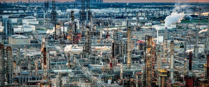 refinery at dusk with industrial buildings and oil and gas storage