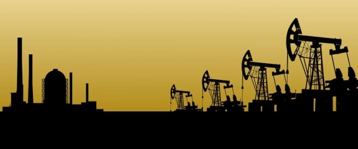 silhouette of oil rigs with a yellow background