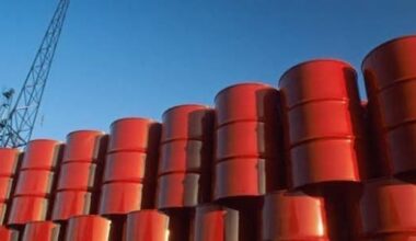Stacked red oil barrels in a depository