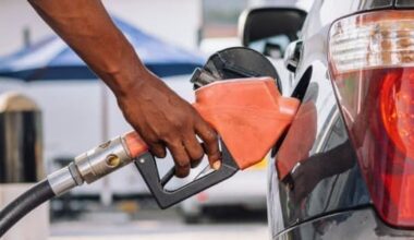 a man pumping gas into his car at a gas station