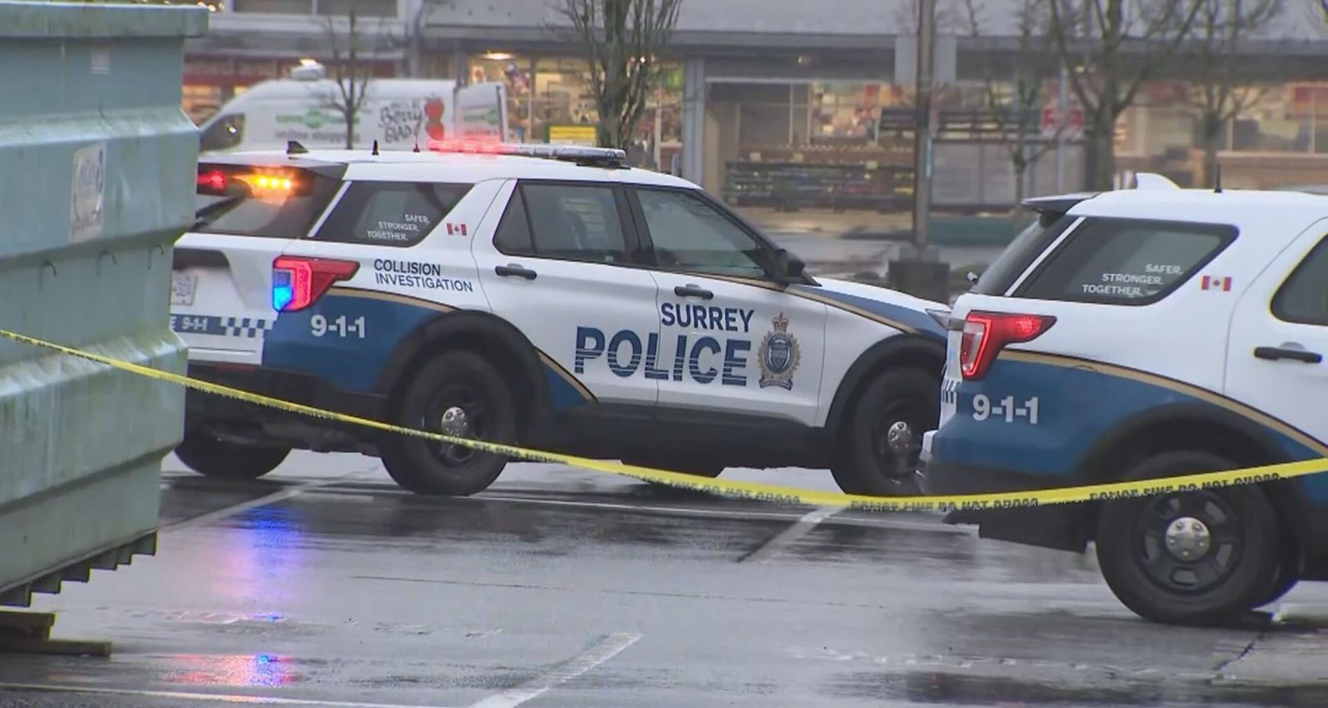 Police vehicles and barricades in a parking lot in Surrey