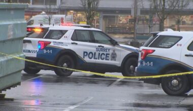 Police vehicles and barricades in a parking lot in Surrey