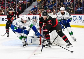 Brady Tkachuk of the Ottawa Senators has puck knocked away by Victor Mancini of the Vancouver Canucks during Jan. 13, 2026 game in Kanata, Ont.
