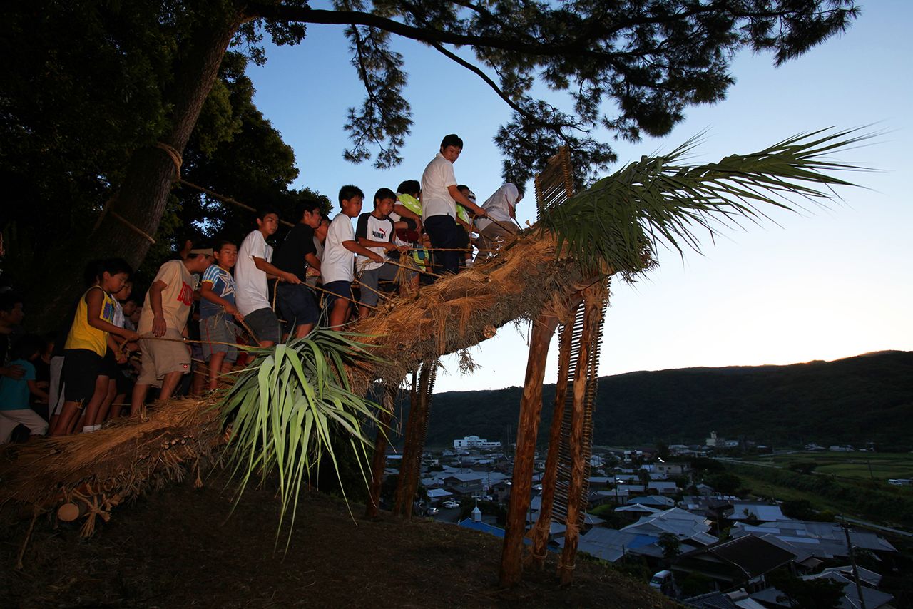 The Akina district in the town of Tatsugō is one of the few areas of Amami Ōshima still growing rice. Shochogama, where the men of the district trample a straw-roofed shed, is a highlight of a local ritual to pray for a good harvest. This is the Akina Arasetsu, which takes place in the eighth month according to the lunisolar calendar. (© Hamada Futoshi)