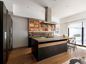The kitchen includes top-of-the-line appliances, walnut cabinetry, stone countertops and a sitting area with sliding glass doors to the backyard.