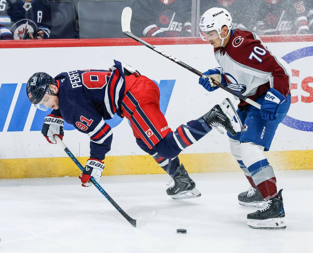 JOHN WOODS / THE CANADIAN PRESS
Colorado Avalanche’s Sam Malinski (70) checks Winnipeg Jets’ Cole Perfetti (91) during second period action in Winnipeg on Saturday.
