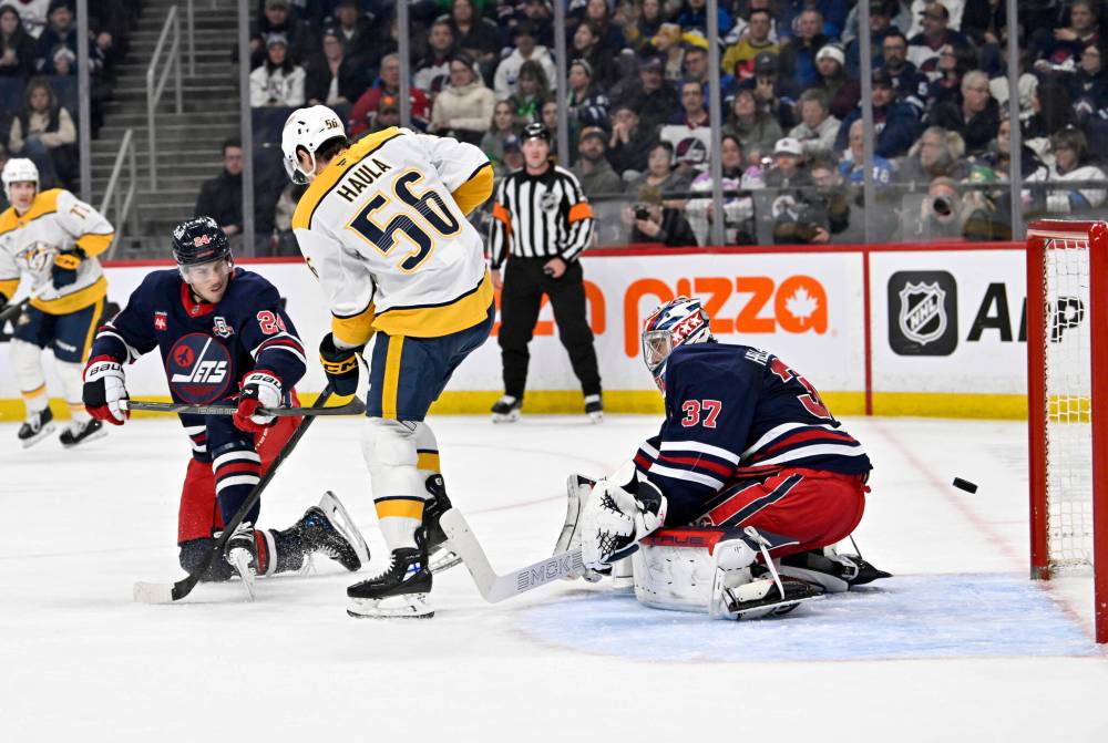 Fred Greenslade / THE CANADIAN PRESS
Nashville Predators’ Erik Haula tips the puck past Winnipeg Jets goaltender Connor Hellebuyck as Haydn Fleury defends during the first period.