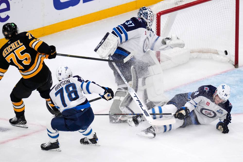 Charles Krupa / The Associated Press
Boston Bruins left wing Lukas Reichel shoots the puck past Winnipeg Jets goaltender Connor Hellebuyck in the second period of the Bruins' 6-1 win, Thursday.