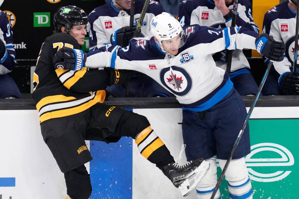 Charles Krupa / The Associated Press
Boston Bruins left wing Lukas Reichel, left, is held back by Winnipeg Jets defenceman Dylan DeMelo in the first period, Thursday in Boston.