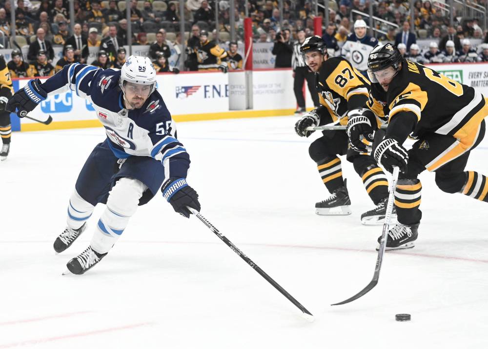 PHILIP G. PAVELY / THE ASSOCIATED PRESS
Winnipeg Jets centre Mark Scheifele (55) and Pittsburgh Penguins defenceman Rickard Rakell (67) reach for the puck as centr eSidney Crosby (87) looks on during the third period Saturday in Pittsburgh.