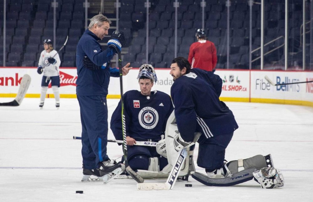 JESSICA LEE / FREE PRESS FILES
Jets goalie coach Wade Flaherty, left, chats with Eric Comrie (centre) and Connor Hellebuyck during team practice in 2021.