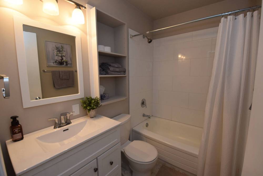 Todd Lewys / Free Press
The main bathroom has been updated with a modern vanity and mirror, and new vinyl-tile flooring, light fixtures and tile bathtub surround.