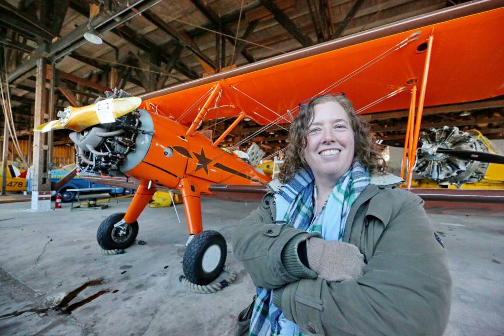 Y MATT GOERZEN / THE BRANDON SUN
Commonwealth Air Training Plan Museum director general Zoe McQuinn poses in front of a 1943-built Boeing Stearman Kaydet, a recent addition to the historic hanger.