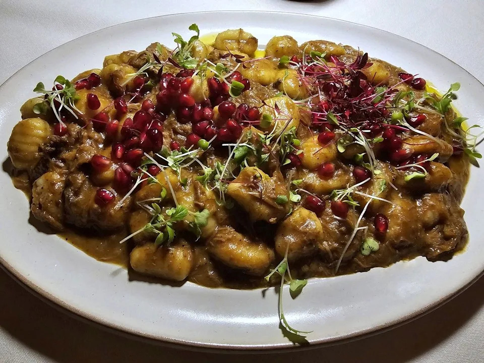 Gnocchi in a slow-braised lamb ragù, scattered with pomegranate seeds.