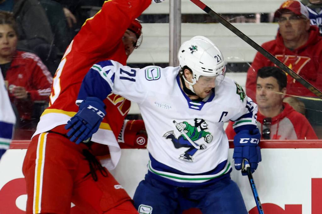 Abbotsford Canucks captain Chase Wouters battles for the puck along the boards during AHL action on Sunday (March 1). (Abbotsford Canucks photo)