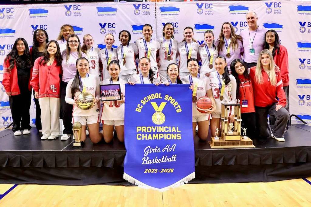 Holy Cross Regional High School senior girls basketball team with 2A division B.C. championship banner at Langley Events Centre on Saturday, Feb. 28, 2026. (Contributed/Garrett James, Langley Events Centre)