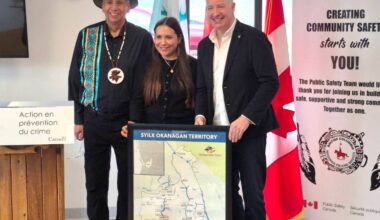 Okanagan Indian Band Chief Dan Wilson wears the necklace given him by Kelowna MP Stephen Fuhr (right), who, in turn, accepts a map of the traditional syilx Okanagan Territory, presented by Okanagan Indian Band Youth Leadership Council chair Kayla Ochoa (centre). The gift exchange came prior to Fuhr announcing $2.14 million for the OKIB to support a community-led project helping Indigenous youth build confidence, connection and leadership. The announcement was made Tuesday, March 3, at Head of the Lake Hall. (Roger Knox - Morning Star)