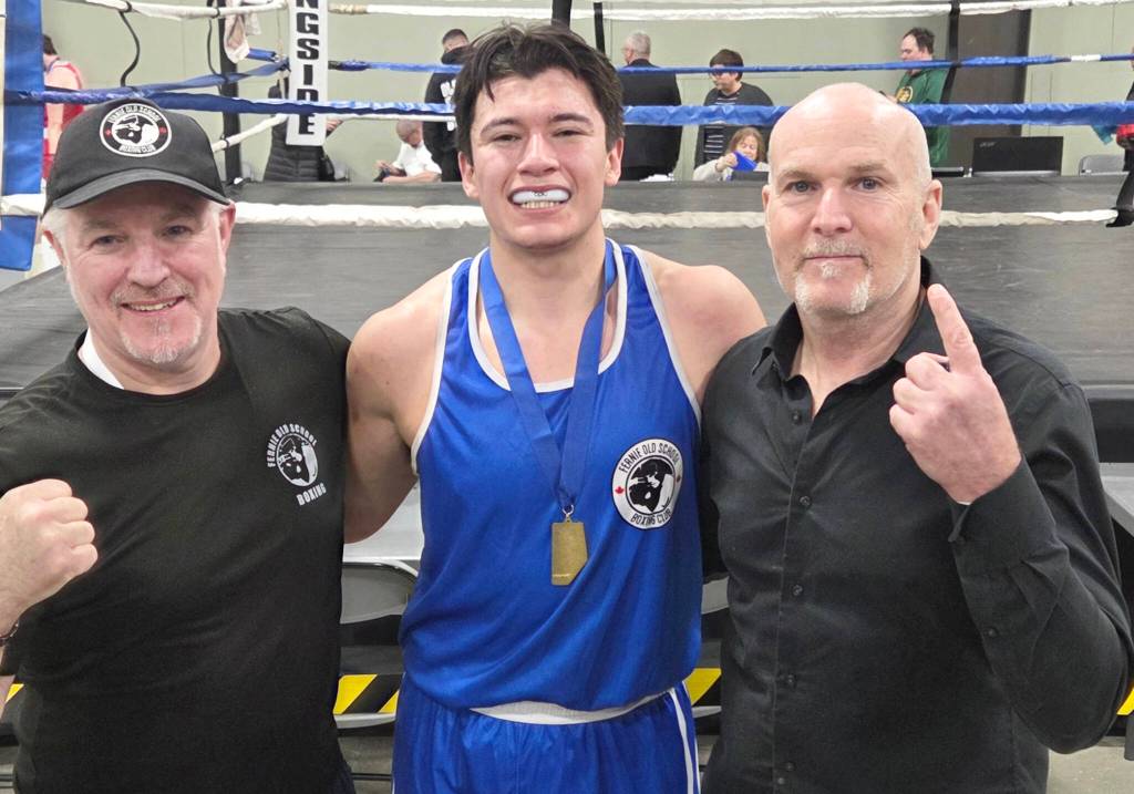 Coaches Mike Johnson and Cam Carr from Fernie Old School Boxing Club stand with elite novice Riley Barr at Provincials in Alberta (Submitted)