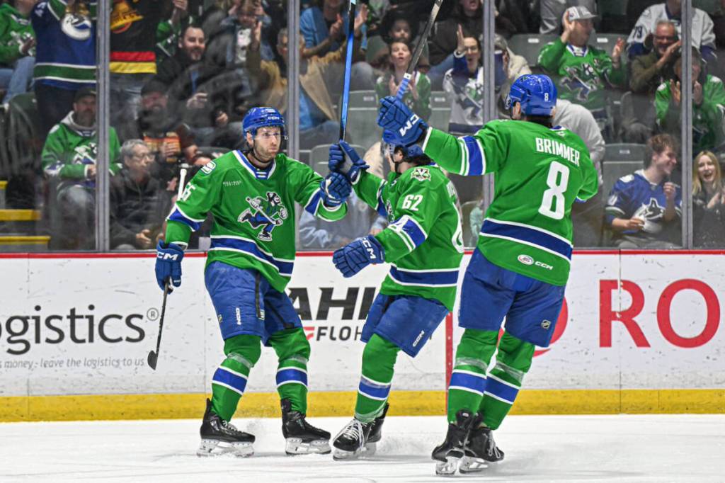 Abbotsford Canucks players congratulate Guillaume Brisebois after he scores a goal in his first home game this season on Saturday (March 28). (Abbotsford Canucks photo)