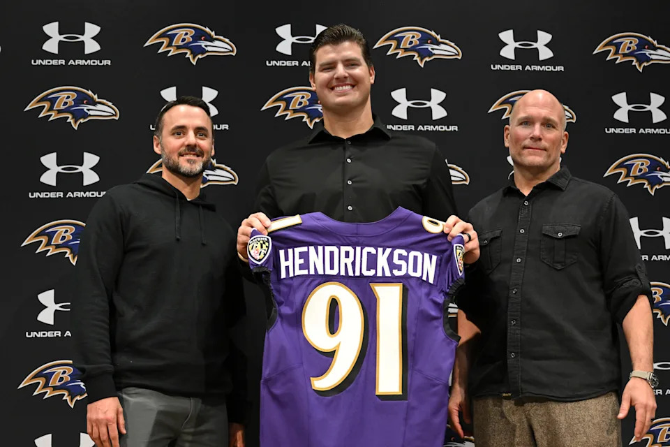 Baltimore Ravens, left to right, head coach Jesse Minter, defensive end Trey Hendrickson and general manager Eric DeCosta pose for a picture during an introductory NFL football press conference Friday, March 13, 2026, in Owings Mills, Md. (AP Photo/Gail Burton)