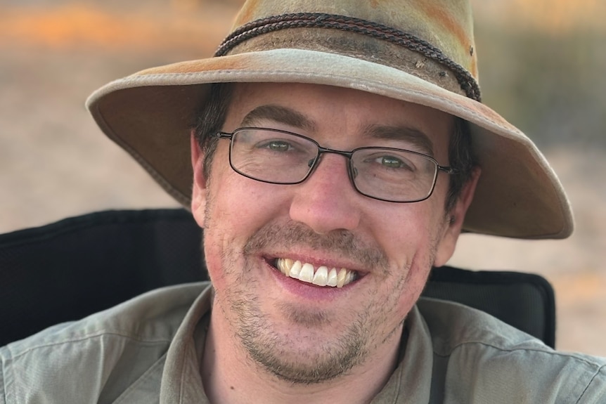 headshot of man in glasses with akubra hat