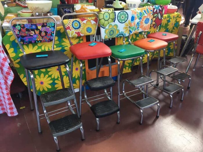 stepstool-style 1960s kitchen chairs with psychedelic vinyl backs.