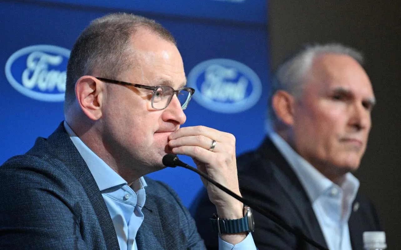 Toronto Maple Leafs general manager Brad Treliving listens to a question during a media conference to introduce new head coach Craig Berube (right) at Ford Performance Centre