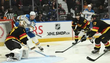 St. Louis Blues left wing Jake Neighbours (63) shoots the puck defended by Vancouver Canucks goaltender Kevin Lankinen (32) and defenseman Filip Hronek (17) during the third period at Rogers Arena.