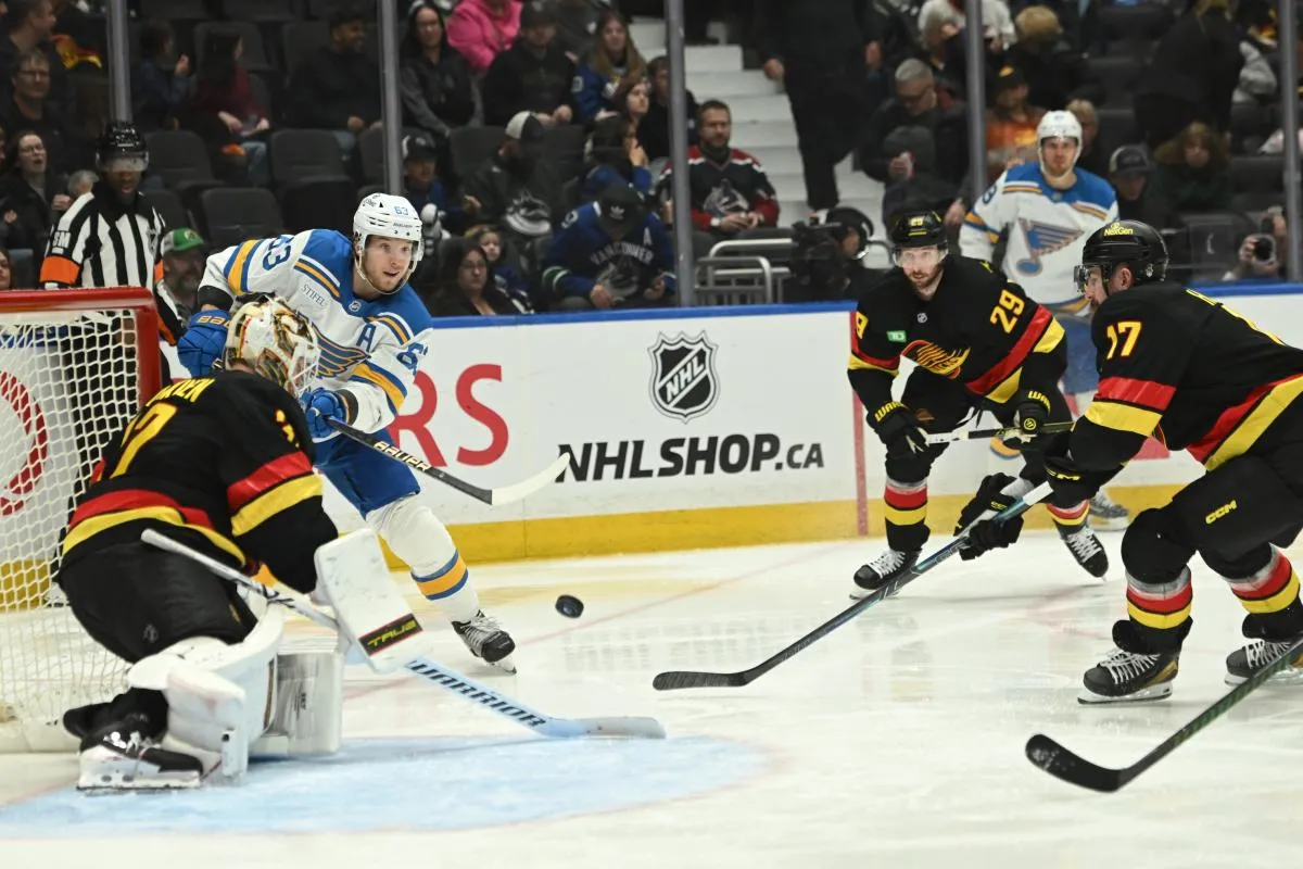 St. Louis Blues left wing Jake Neighbours (63) shoots the puck defended by Vancouver Canucks goaltender Kevin Lankinen (32) and defenseman Filip Hronek (17) during the third period at Rogers Arena.