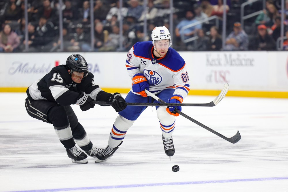 Edmonton Oilers left wing Andrew Mangiapane, right, moves the puck against Los Angeles Kings center Alex Turcotte during the third period of an NHL hockey game Thursday, Feb. 26, 2026 in Los Angeles. (AP Photo/Ryan Sun)