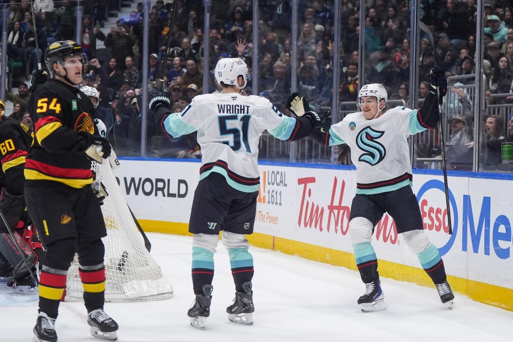 Seattle Kraken's Bobby McMann, right, and Shane Wright celebrate McMann's goal as Vancouver Canucks' Aatu Raty (54) looks on during the first period of an NHL hockey game, in Vancouver, on Saturday, March 14, 2026. THE CANADIAN PRESS/Darryl Dyck