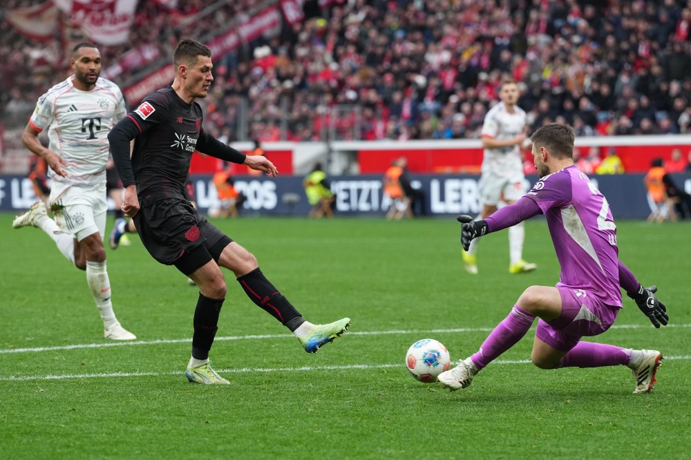 Leverkusen's Patrik Schick, second left, makes an attempt to score past Bayern's goalkeeper Sven Ulreich during a German Bundesliga soccer match between Bayer Leverkusen and Bayern Munich in Leverkusen, Germany, Saturday, March 14, 2026. (AP Photo/Martin Meissner)