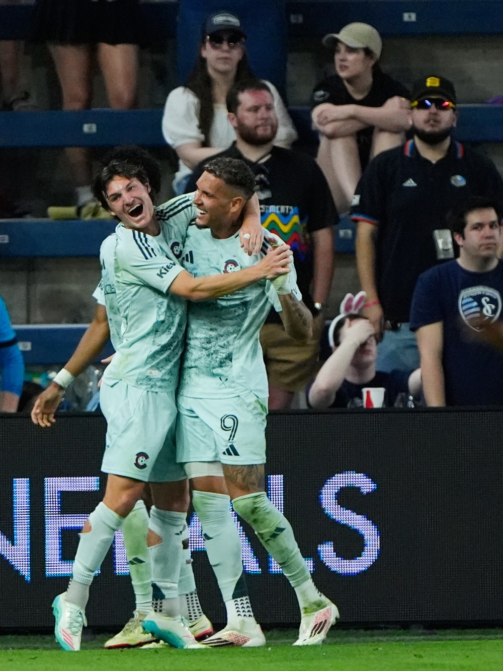 Colorado Rapids midfielder Paxten Aaronson, left, celebrates with forward Rafael Navarro (9) after Navarro scored a goal during the second half of an MLS soccer match against Sporting Kansas City, Saturday, March 21, 2026, in Kansas City, Kan. (AP Photo/Charlie Riedel)