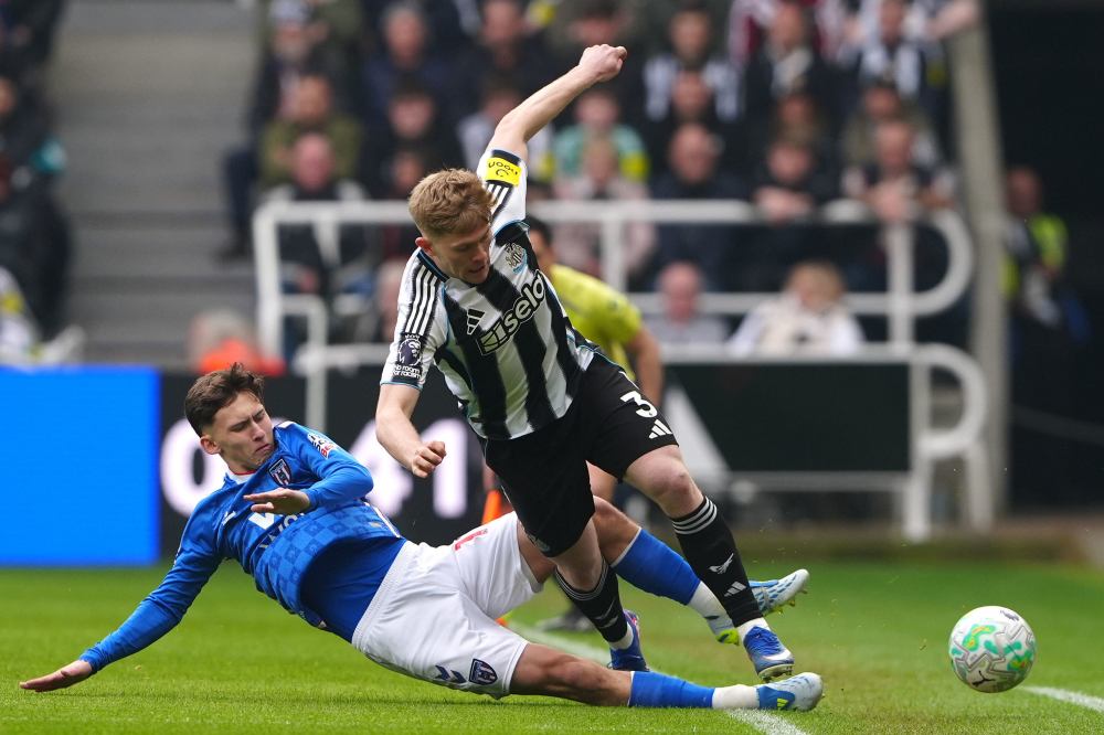 Sunderland's Chris Rigg, left, and Newcastle United's Lewis Hall battle for the ball during the Premier League match between Newcastle and Sunderland outside St James' Park, Newcastle upon Tyne, England, Sunday March 22, 2026. (Owen Humphreys/PA via AP)