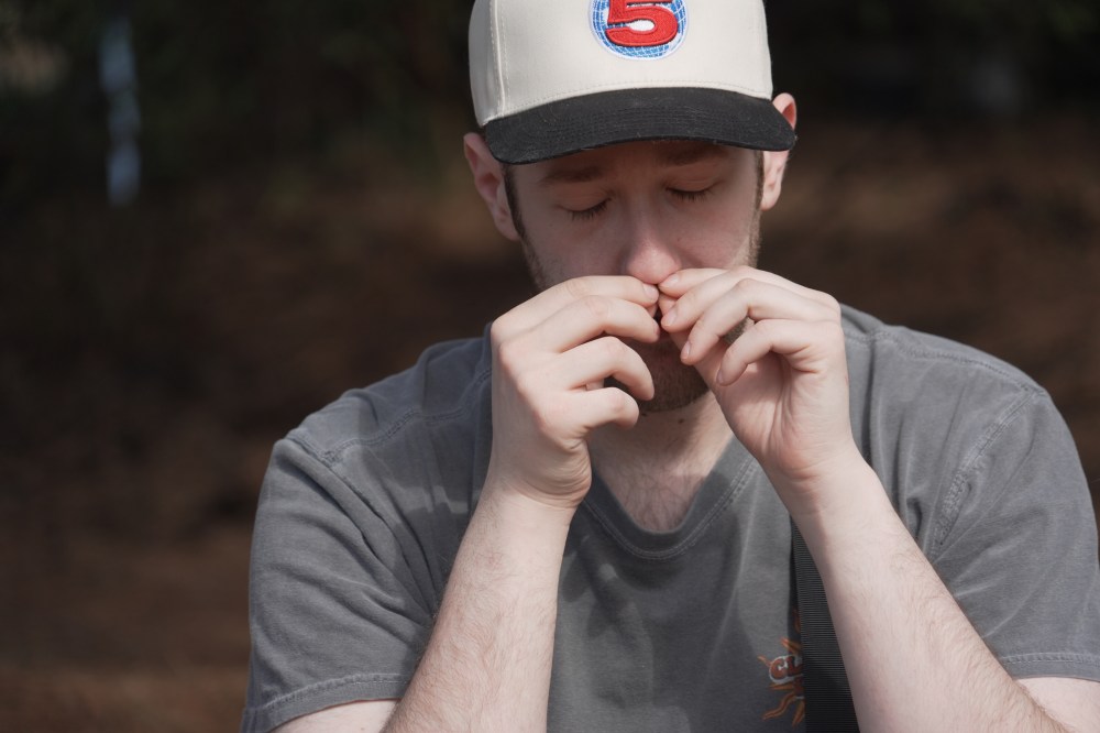 Alan Mintz smells a crushed conifer twig during a
