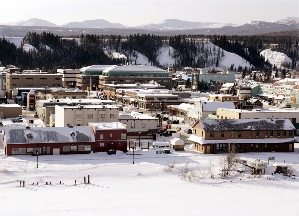 The city of Whitehorse, surrounded by mountains, sits on the banks of the Yukon River (foreground) covered in snow on winter March day 2007. (CP PHOTO/Chuck Stoody)