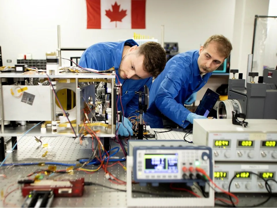  (left to right) Junior mechanical engineer in training Brandon Hodge and optical engineer in training Elliot Saive work on a deployable optics prototype, an advanced hyper spectral imaging telescope system for satellites, in the Wyvern laboratory, in Edmonton Friday, March 27, 2026.