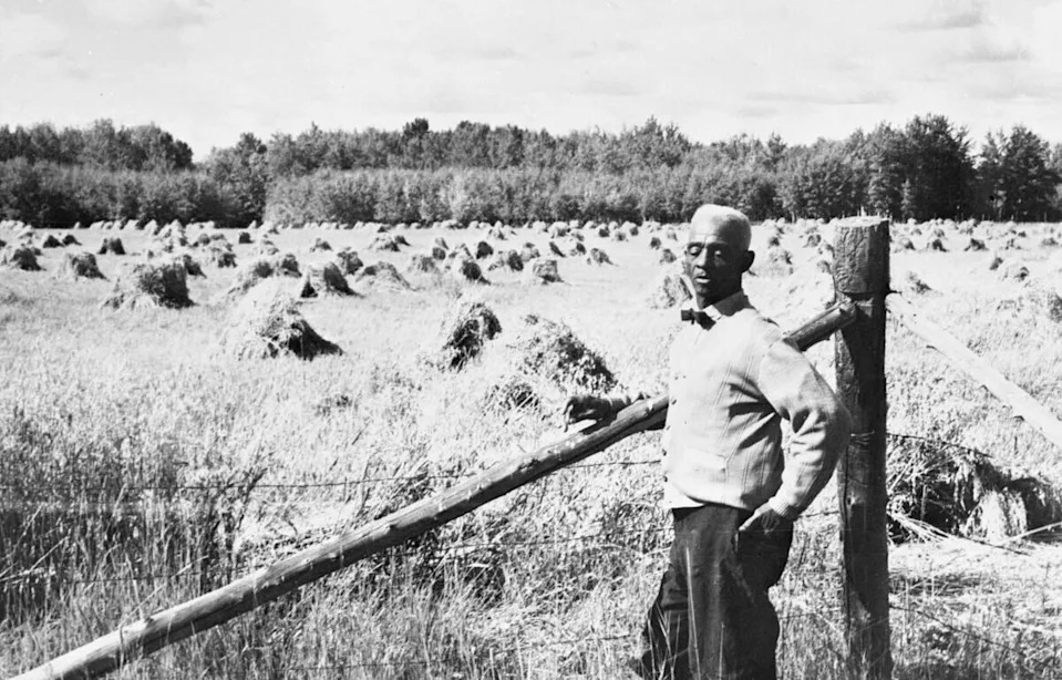  J. D. Edwards stands beside a grain field in Amber Valley, Alta., sometime between 1947 and 1949.