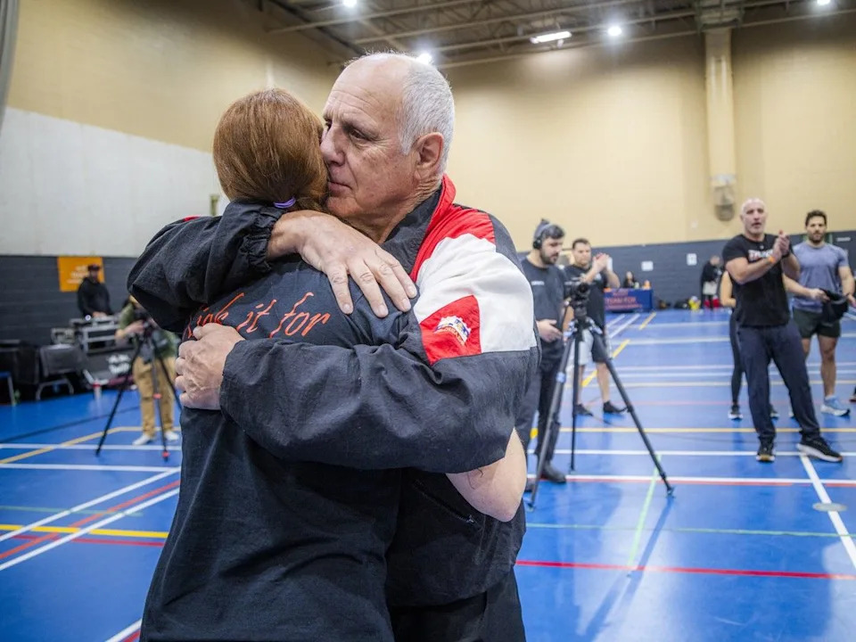  Jean-Yves “The Iceman” Theriault, a former world kick-boxing champion, and Chantal Theriault’s father, gives her a hug during the Kick It for Parkinson event on Saturday.