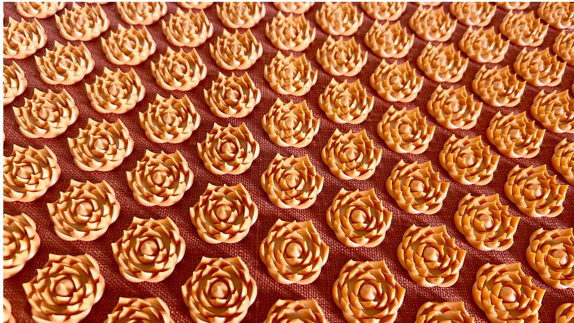 A close up of the lotus-shaped spikes on an orange acupressure mat