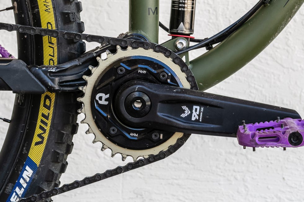 Bicycle crankset with a chain and pedals.