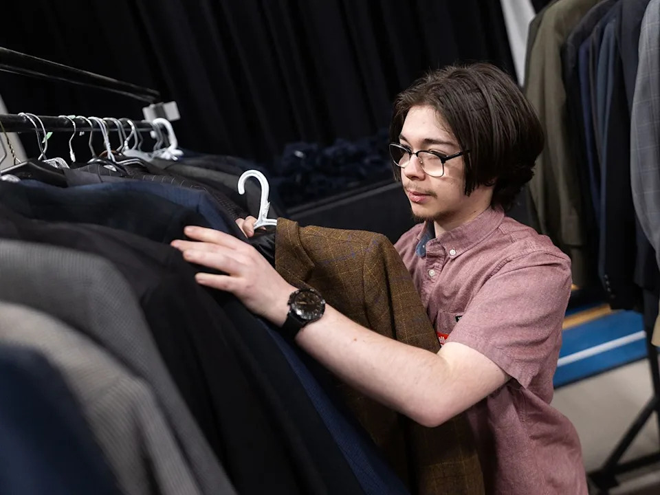 Youth volunteer Kyle Fraser organizes formalwear for weekend one of the GRADitude Project in Calgary on Sunday, March 15, 2026. Organized by the Trellis Society, the program outfits Grade 12 students with graduation attire regardless of financial circumstances.
