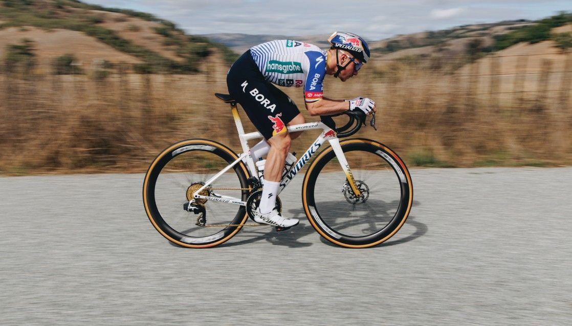Remco Evenepoel riding in an aero tuck posistion in Red Bull Bora kit