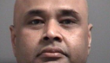 Police officers examining a stockpile of alcohol, butter, and ghee in a Brampton residence related to retail theft investigation