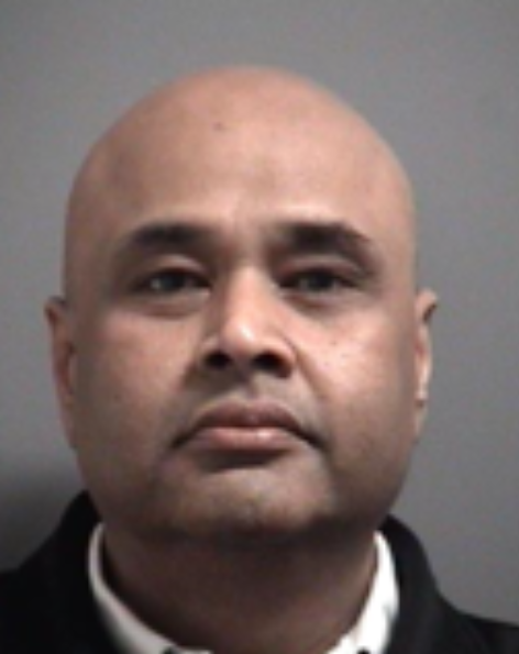 Police officers examining a stockpile of alcohol, butter, and ghee in a Brampton residence related to retail theft investigation