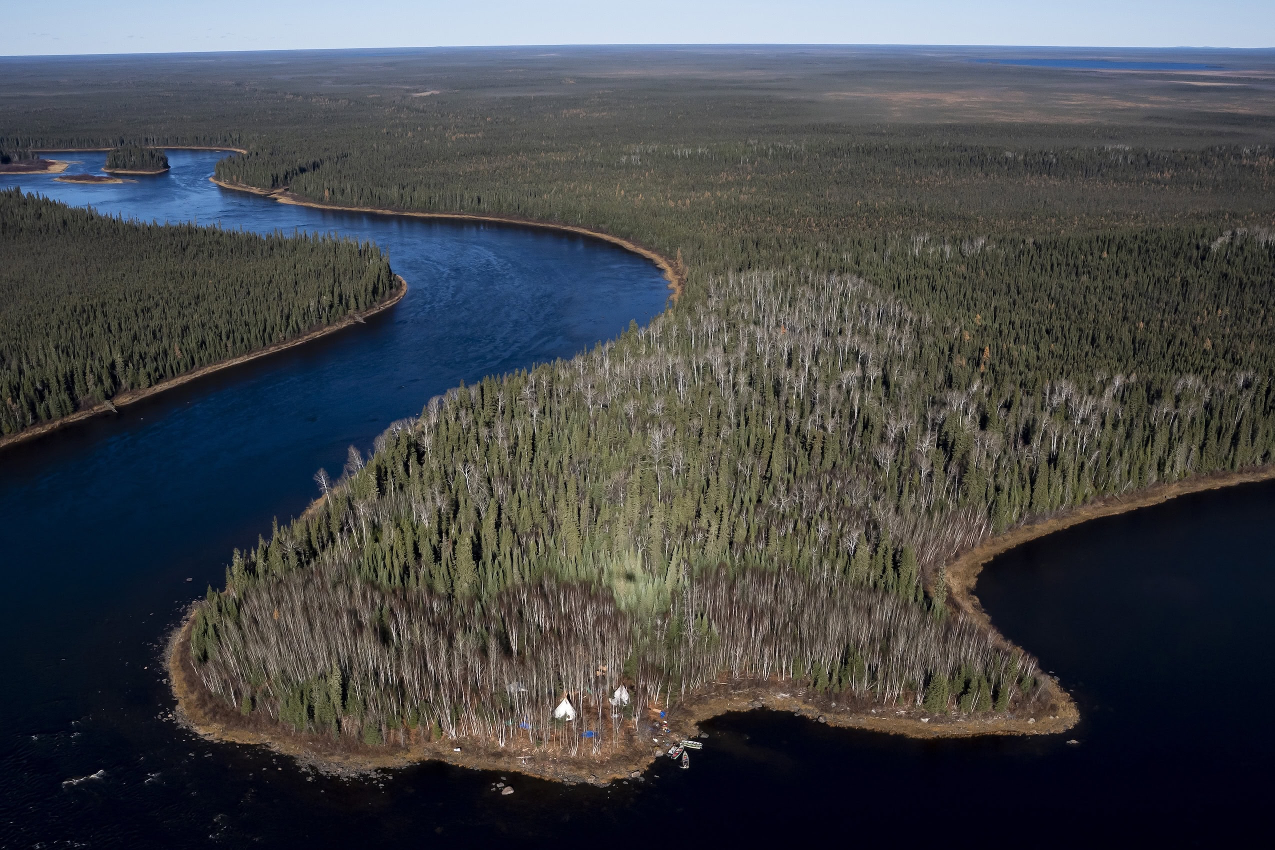 An aerial image of a large river bending its way through a vast natural landscape.