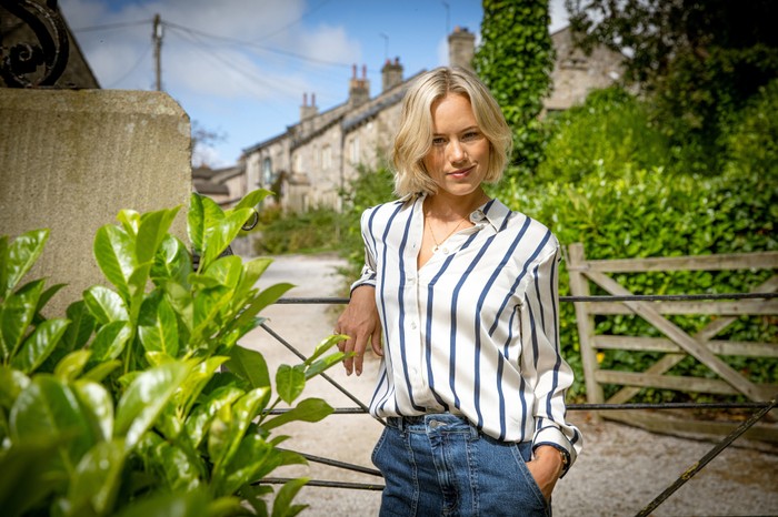 EMBARGO_EMM_STEPH Georgia Jay poses as Steph Miligan in the Emmerdale village, leaning on a fence