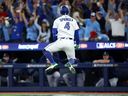 George Springer #4 of the Toronto Blue Jays celebrates after hitting a three-run home run against the Seattle Mariners during the seventh inning in game seven of the American League Championship Series at the Rogers Centre on October 20, 2025 in Toronto, Ontario.