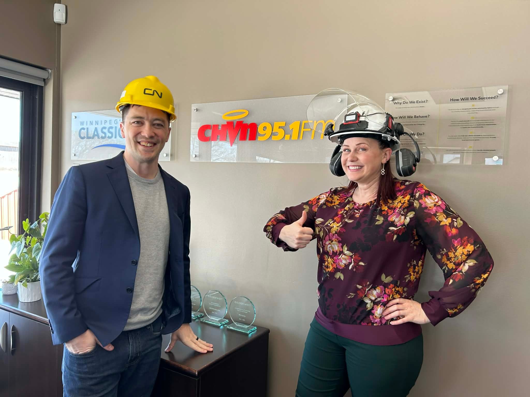 Craig Neufeld (left) and Sylvia St. Cyr (right), wearing their gifts from CN Symington Yard in Winnipeg. 