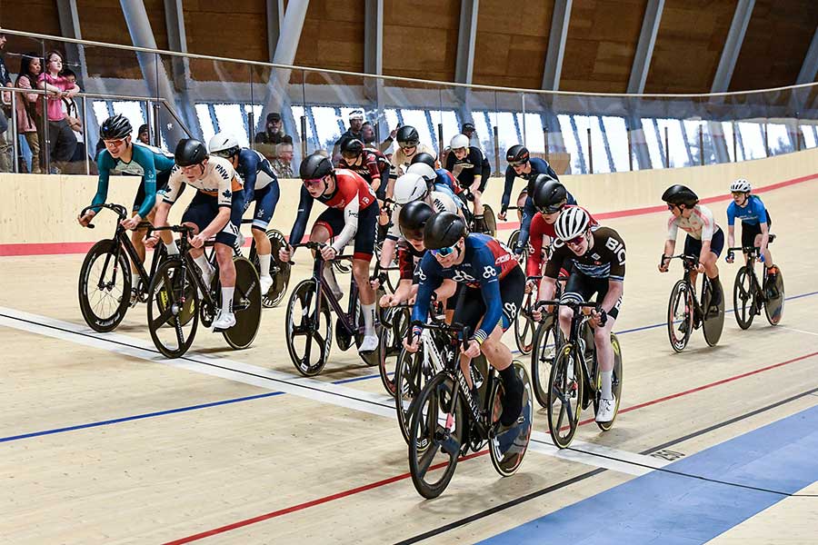 Cyclists riding on the velodrome track.